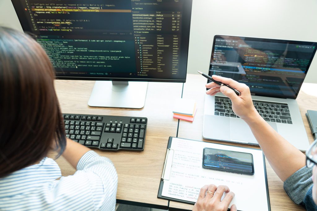 two people looking at code on computer