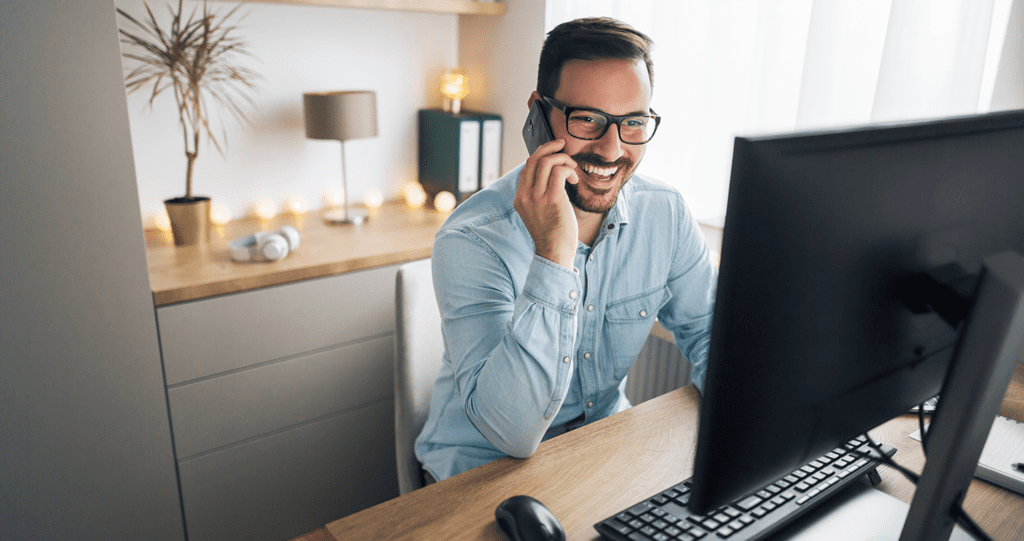 man on phone working from home at computer