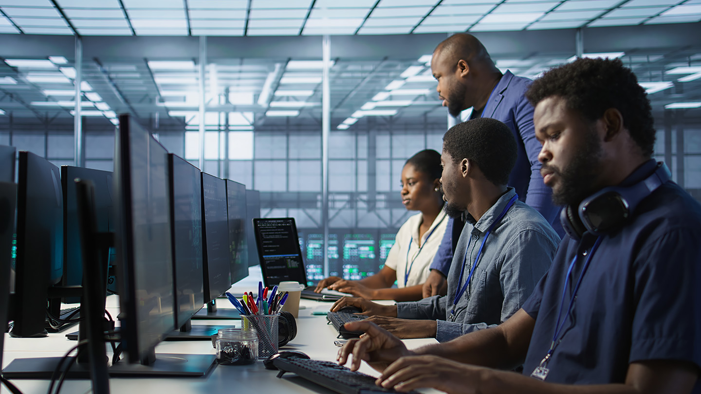Teamworking computer scientists talking in server room, developing disaster recovery plans. Team of data center office coworkers doing brainstorming, monitoring metrics across devices