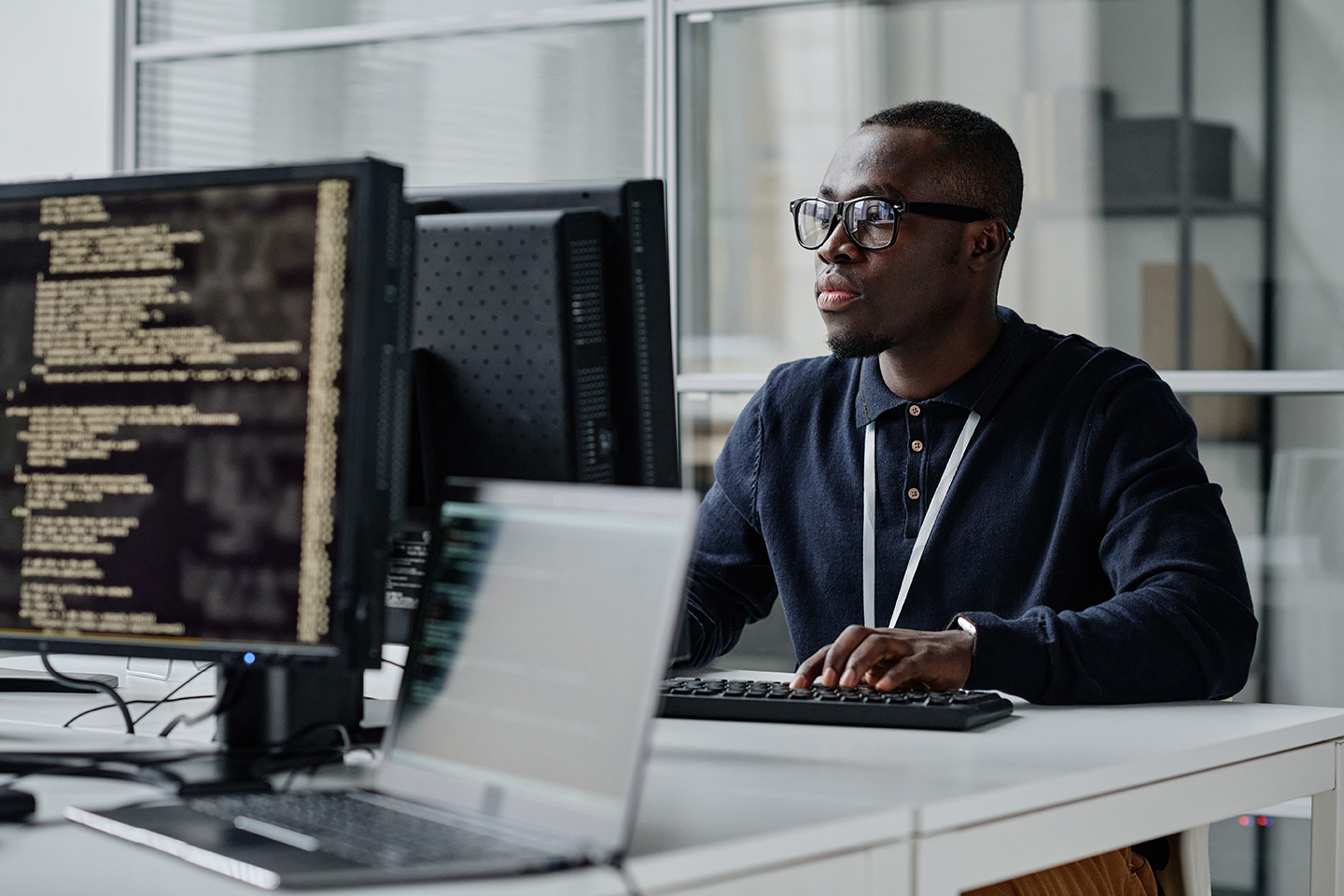 young developer concentrating on his online work on computer sitting at workplace