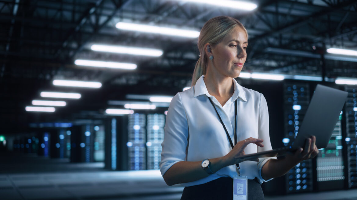 High Speed Data Transfer and Smooth Server Operation. Female Engineer Programs Something and Looking at Laptop Computer while Works in Dark Modern High Tech Office. Analytics and Statistics Concept